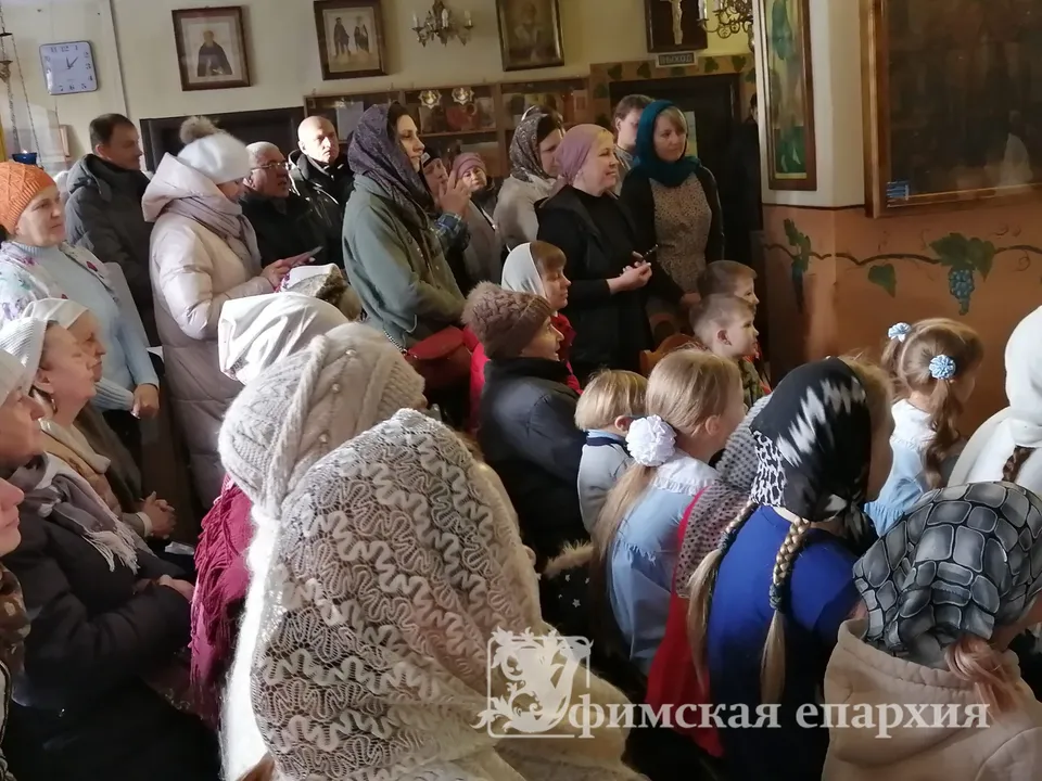 Прихожане во временном храме на рождественском представлении, на стенах — иконы