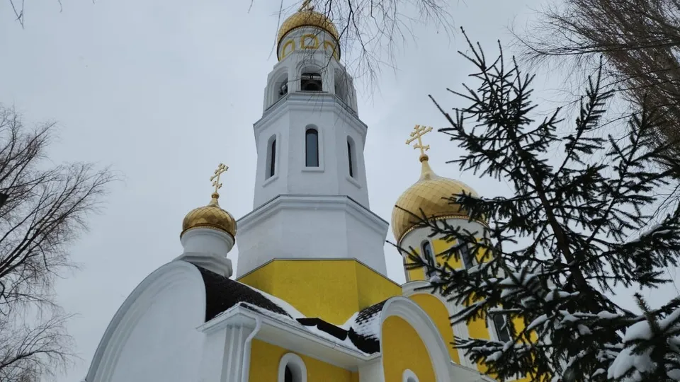Белая шатровая звонница и малый золочёный купол нового храма крупным планом